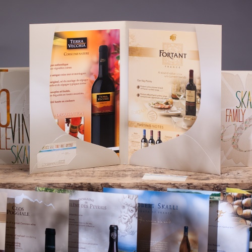 Ensemble de créations graphiques pour les vins Skalli : Design de pochette chemise avec découpe sur mesure, création de plaquettes de vin, fiches d'aide à la vente, design des cartes de visite